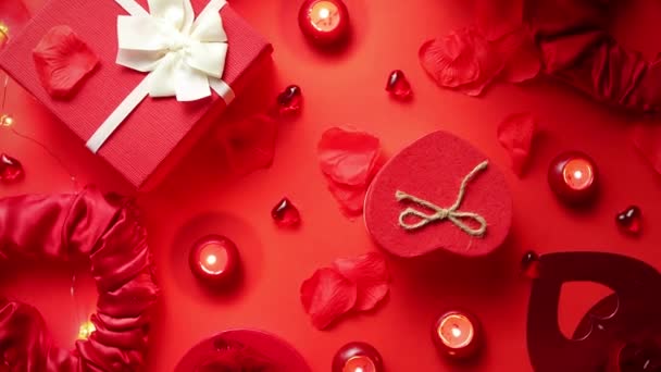 Sevgililer günü gül, kutulu hediyeler, mumlar, bir kırmızı arka plan tablo ile romantik dekorasyon. Üstten görünüm, kopya alanı. - Video, Çekim