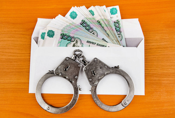 Handcuffs on the Envelope with Russian Rubles on the Table - Photo, Image