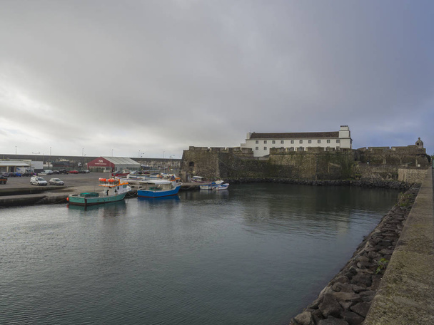 Portugalia, Sao Miguel w Ponta Delgada, Azory, 21 grudnia 2018: Forte de São Bras w mieście Ponta Delgada Zobacz o rybackich portu i łodzi z historycznych fortyfikacji, w pobliżu centrum miasta w Ponta - Zdjęcie, obraz
