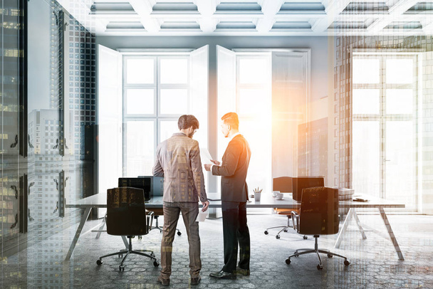 Two businessmen in modern office interior with gray and white walls, hexagonal pattern floor, big white table with laptops and windows with white shutters. Toned image double exposure - Photo, image