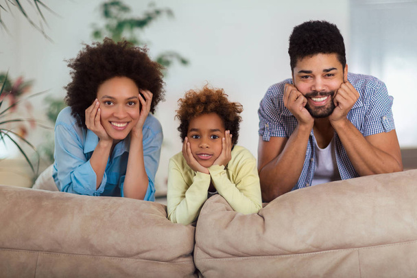 Happy family posing on the couch together at home in the living room, selective focus. - Foto, imagen