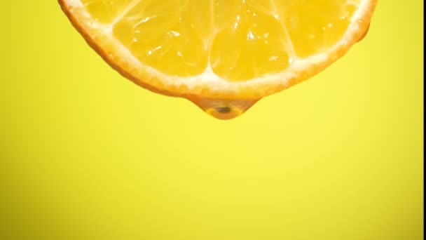 Wasser tropft auf eine Orangenscheibe, Obst für die Ernährung und gesunde Ernährung. Gelber Rückgrat - Filmmaterial, Video