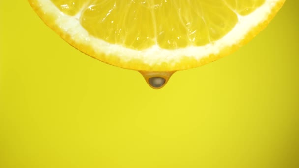 Agua cayendo en una rebanada de naranja, frutas para la dieta y alimentos saludables. Respaldo amarillo
 - Imágenes, Vídeo