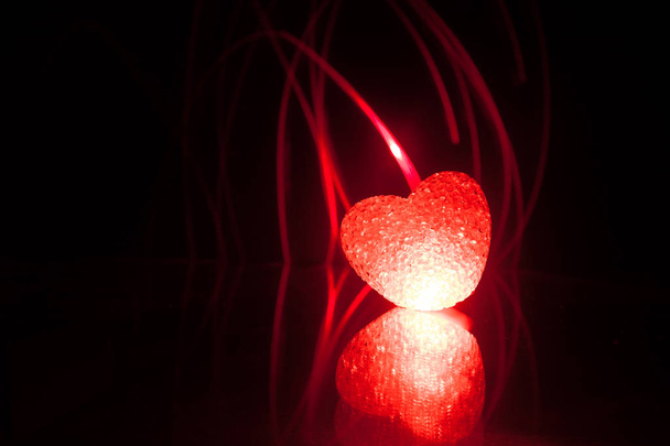 Dark table,Valentines day concept and love red shape heart with bokeh background, empty for text and placing products with copy space. Blurred glowing heart on a dark background with reflection - Φωτογραφία, εικόνα