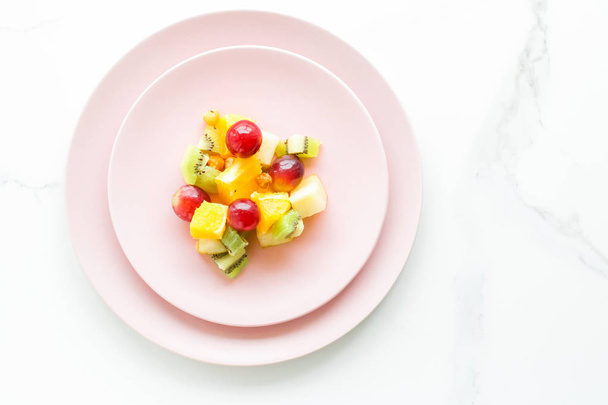Saftiger Obstsalat zum Frühstück auf Marmor, Flatlay - Diät- und gesundes Lifestylekonzept - Foto, Bild