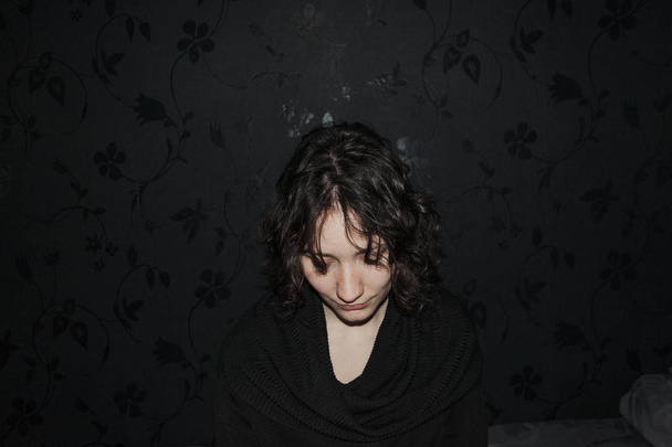 Retrato de uma menina bonita tímida olhando para baixo vestida com roupas pretas
 - Foto, Imagem