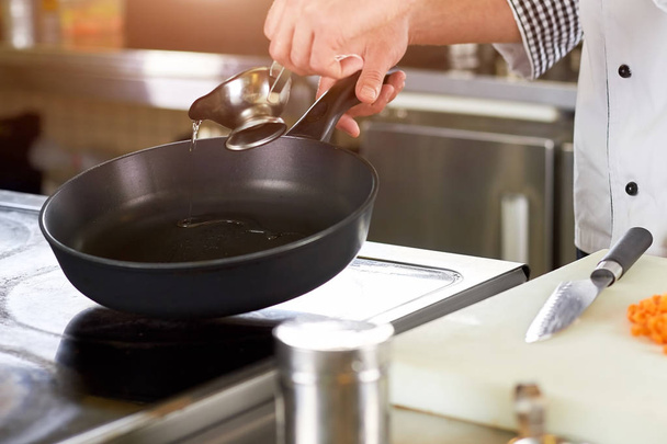 Chef greasing pan with oil. - Foto, Bild