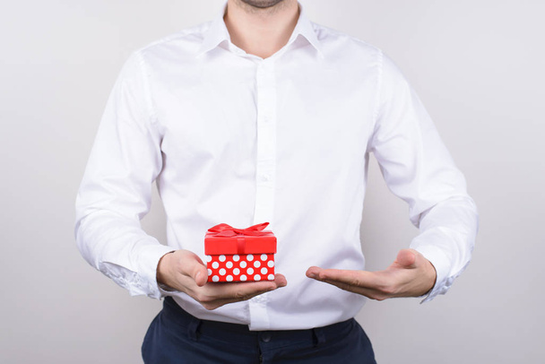 Close up photo of handsome happy masculine charming in formalwear clear classic classy chic shirt man holding little paper dotted box in hand isolated grey background - Фото, зображення