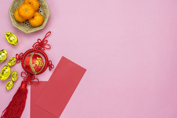 Idioma chino significa rico o rico y feliz.Table vista superior Lunar Año Nuevo y Año Nuevo chino concepto background.Flat lay objeto el dinero de bolsillo naranja y rojo con decoración de la fortuna en papel rosa
. - Foto, imagen