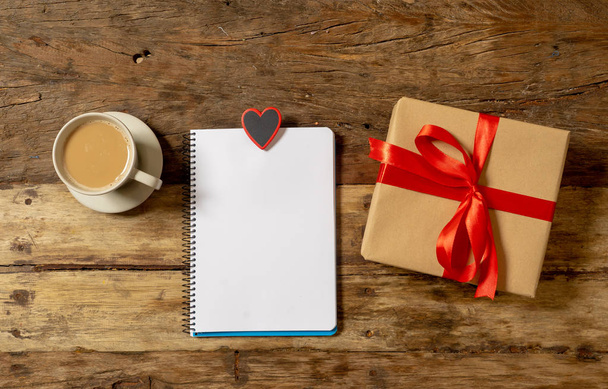 Beautiful Valentines composition of gift, chocolate heart shaped, coffee and noted pad with blank paper space for text in Happy Valentines, Mothers and fathers day and love celebration concept. - Φωτογραφία, εικόνα