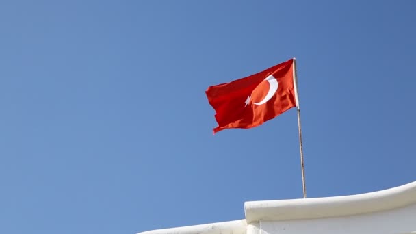 Turecká vlajka pohybující se větrem proti modrému nebi - Záběry, video