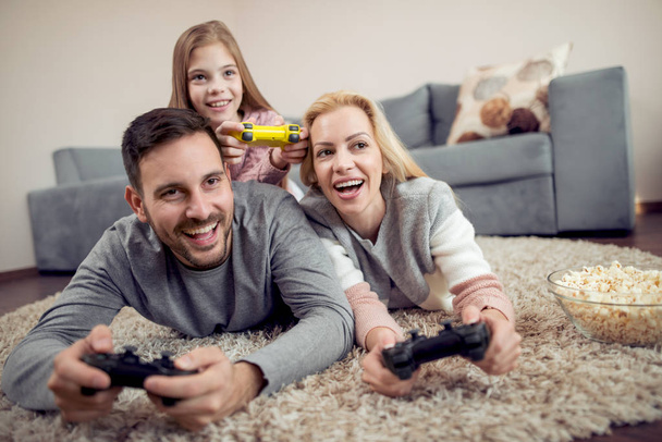 hravá rodina spolu hrají videohry v obývacím pokoji. - Fotografie, Obrázek