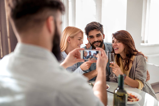 Дозвілля, дружба, люди та свята концепція - щасливі друзі обідали та фотографували зі смартфоном
. - Фото, зображення