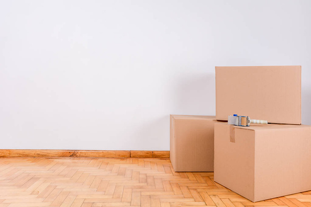 Stack of cardboard boxes in the empty room with copy space. Move concept - Foto, imagen