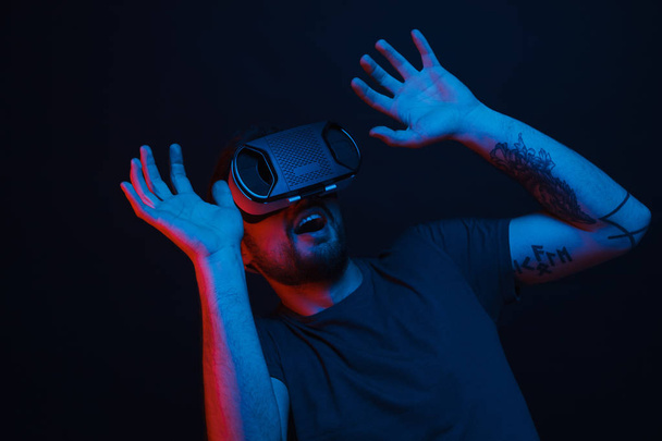 Shocked male in VR headset in dark room - Photo, Image