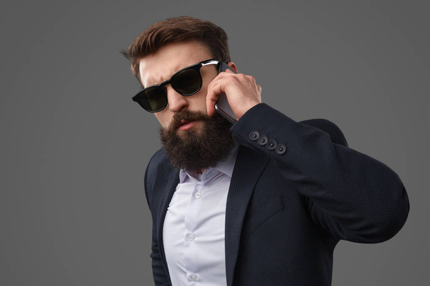 Confident bearded businessman speaking on phone - Foto, Imagen
