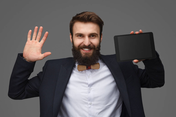 Smiling guy raising hands with tablet - Foto, afbeelding