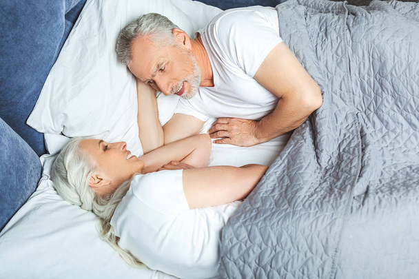 overhead view of wife and husband lying in the bed before sleeping - Foto, immagini
