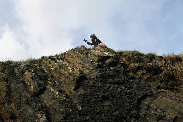 junge Frau macht Selfies mit der Landschaft am Rande der Klippe - Foto, Bild