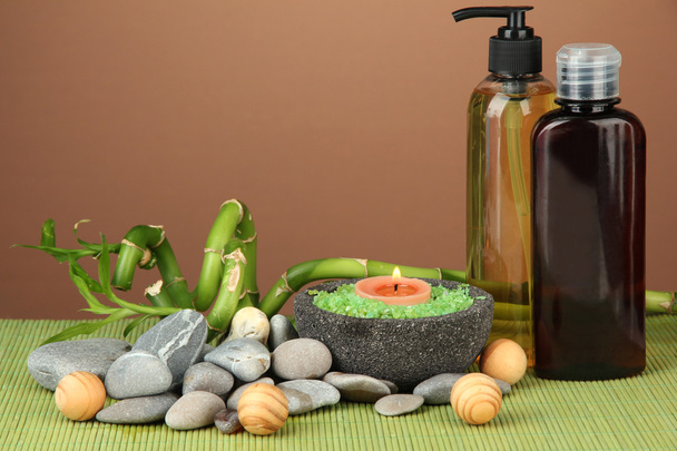 Still life with green bamboo plant and stones, on bamboo mat on color background - Photo, Image