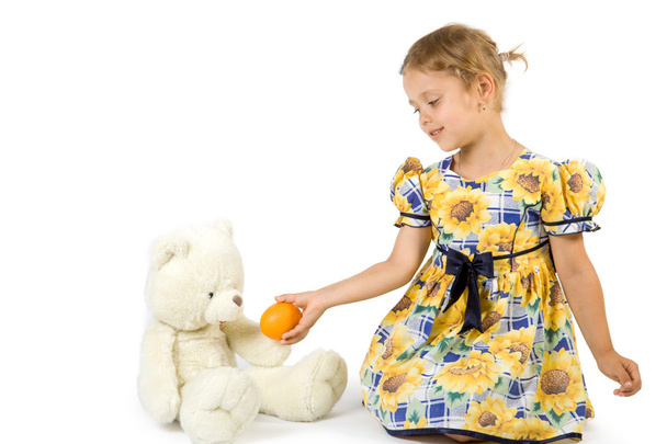Little girl with orange and bear toy. - Foto, Imagem