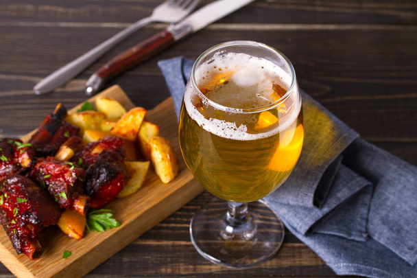 Glass of beer and grilled pork spare ribs with fry, tasty snack to beer. Beer and food concept. Ale and meat  - Foto, imagen
