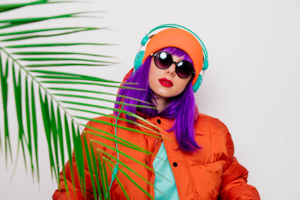 girl with purple hair in jacket with headphones - Фото, изображение