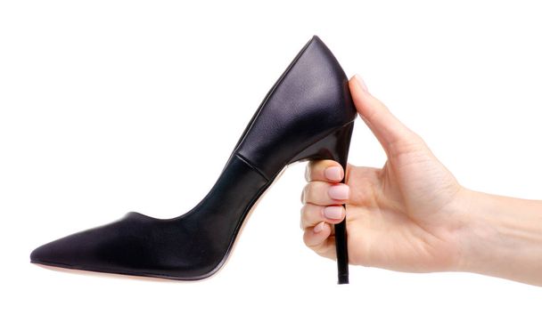 Female black leather high heels shoes in hand - Zdjęcie, obraz