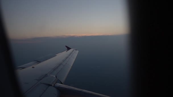 Widok latającego skrzydła samolotu przez okno samolotu. - Materiał filmowy, wideo