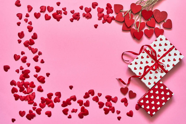 Valentines Day background. Red hearts and gift boxes on pink background. Copy space, top view. Flat lay of Valentines Day celebration concept - Photo, Image