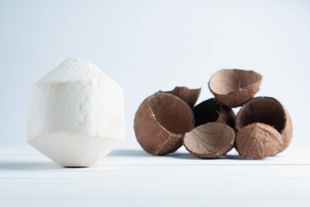 Drinking coconut and split brown coconuts in the white background. - Foto, immagini