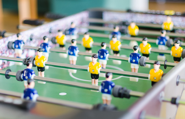 Настільна футбольна гра з жовтими і синіми гравцями
 - Фото, зображення