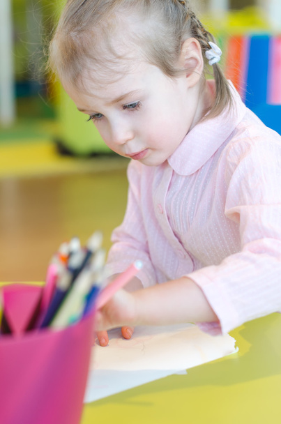 Little girl is drawing with pen in preschool - Фото, изображение