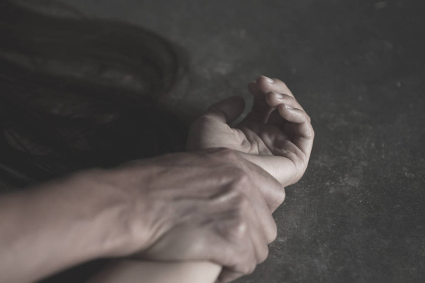 Journée internationale de la femme : Gros plan sur les mains d'un homme tenant une femme pour viol et abus sexuels, lutte contre la traite et arrêt de la violence contre les femmes - Photo, image