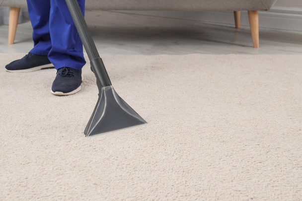 Man removing dirt from carpet with vacuum cleaner indoors, closeup. Space for text - Fotografie, Obrázek