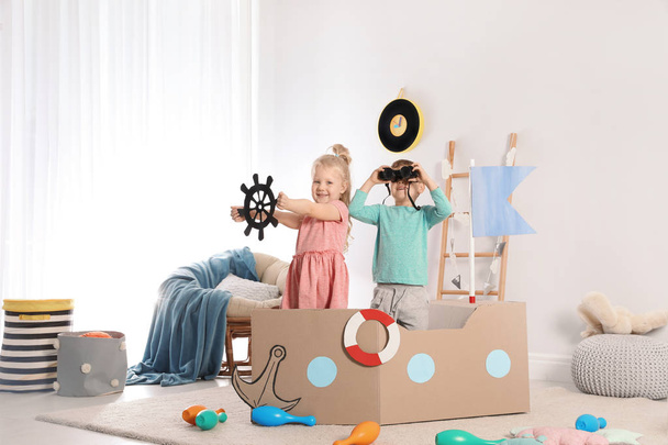 Cute little girl playing with cardboard dragon at home - Foto, Imagem