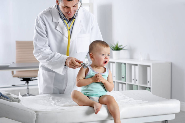 Lasten lääkäri tutkii pientä poikaa stetoskoopilla sairaalassa
 - Valokuva, kuva