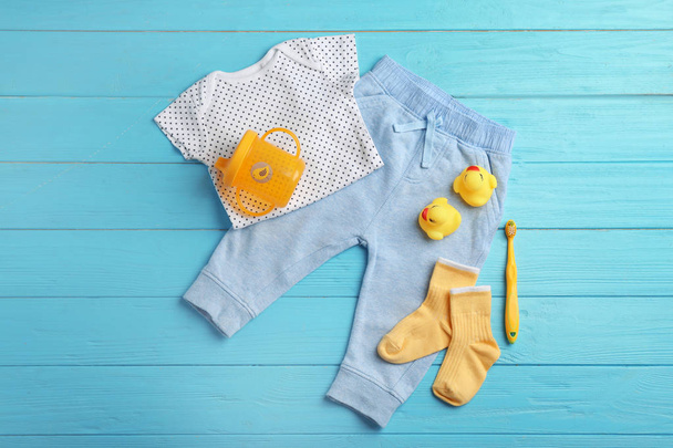 Flat lay composition with cute clothes on wooden background. Baby accessories - Photo, Image
