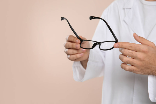 Male ophthalmologist with eyeglasses on light background, closeup. Space for text - Valokuva, kuva