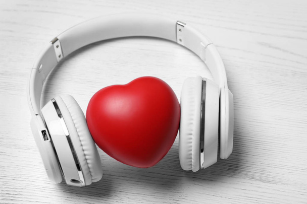 Headphones and heart on white wooden background - Photo, Image