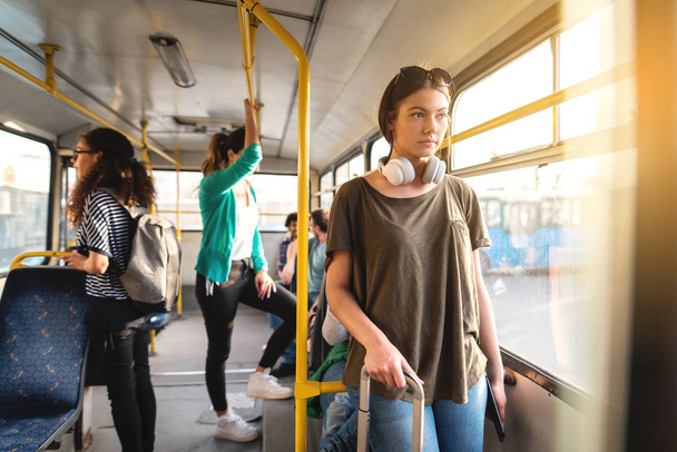young beautiful woman listening to music on headphones in bus - Photo, Image