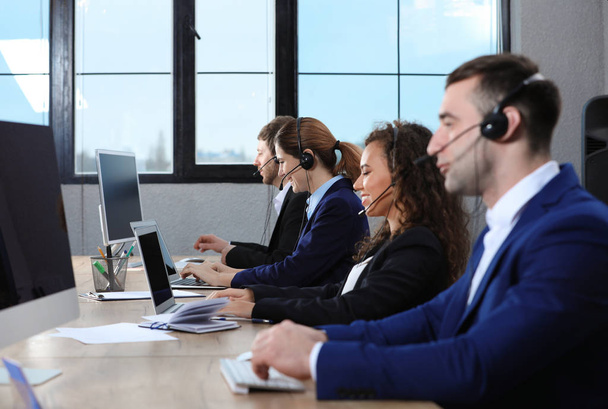 Team of technical support with headsets at workplace - 写真・画像