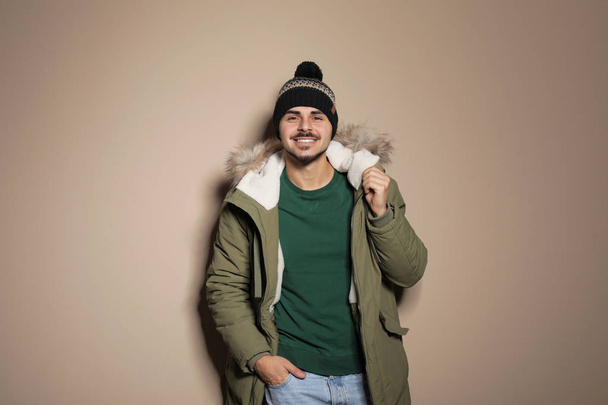 Renk arka plan üzerinde sıcak giysiler giyen genç adam. Kış tatili için hazır - Fotoğraf, Görsel