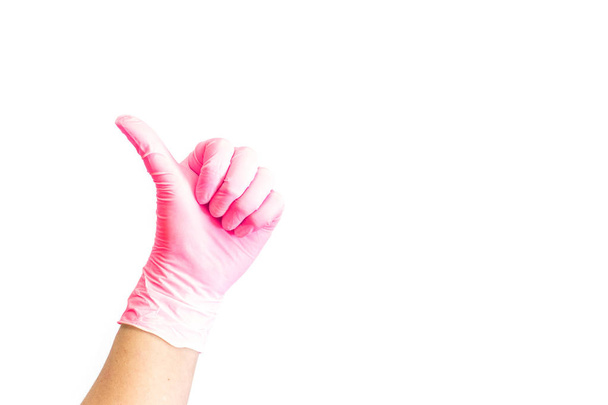 Γυναικεία χέρια σε λευκό ιατρικά γάντια δείχνει σαν σημάδι.  - Φωτογραφία, εικόνα