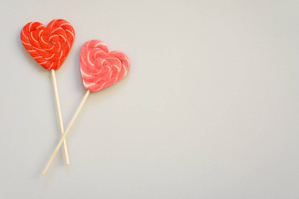Red and pink lollipop. Candy in the form of heart. - Photo, image