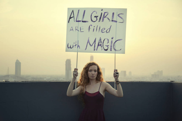 Dívka stojí na střeše s plakát "všechny holky jsou vyplněny s magií" koncept mezinárodní den Dámské - Fotografie, Obrázek