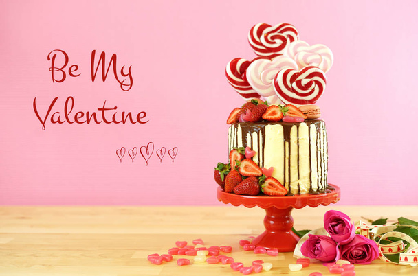 Valentines Day candyland drip cake decorated with heart shaped lollipops. - Fotoğraf, Görsel