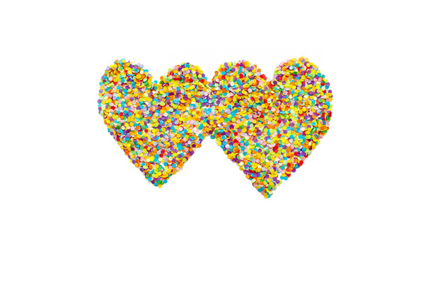 Heart made of colored confetti. Small circles of colored paper. White background. View from above. Colored heart. - Valokuva, kuva