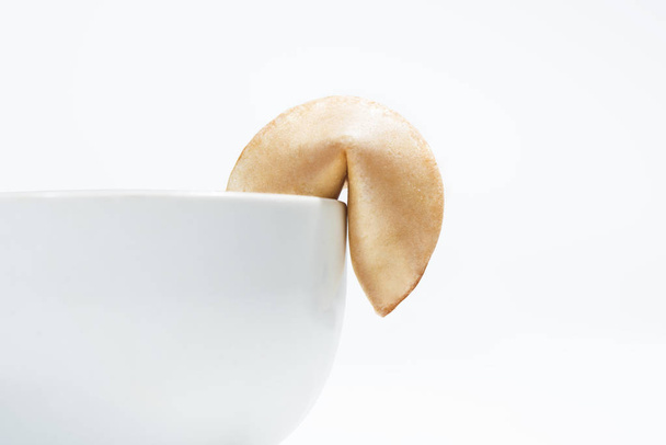 Fortune cookie on edge of bowl, close up - Foto, afbeelding
