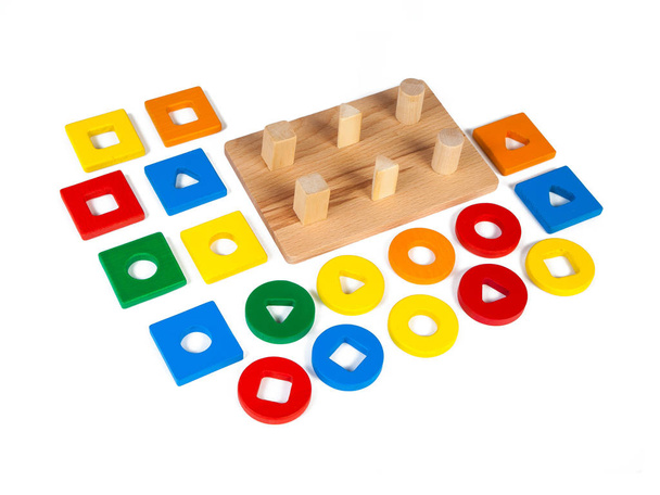 Geometrik şekiller (dikdörtgen, kare, çember, üçgen) şeklinde küçük ahşap detayları olan tahta oyuncak çocuk ayırıcısının resmi, beyaz izole bir arkaplanda farklı renklerde. - Fotoğraf, Görsel